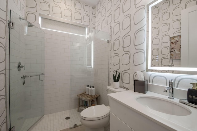 bathroom with vanity, toilet, and a shower with door