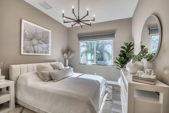 bedroom with hardwood / wood-style flooring and a notable chandelier