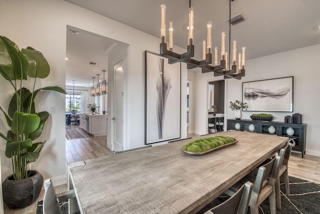 dining room with light wood-type flooring and a chandelier