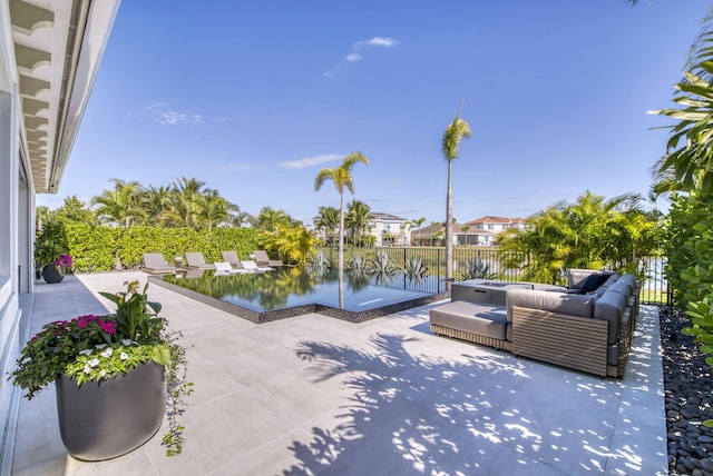 view of patio featuring a water view, an outdoor living space, and a hot tub