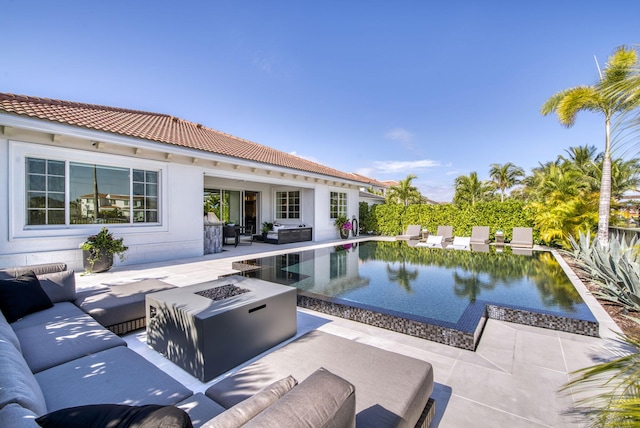 view of pool with an outdoor living space with a fire pit, area for grilling, and a patio