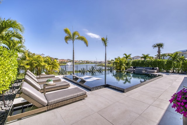 view of swimming pool featuring a water view and a patio