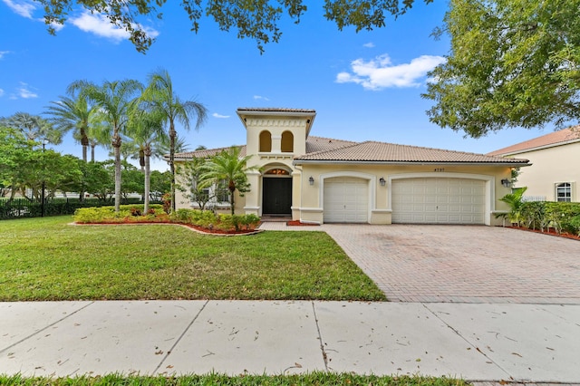 mediterranean / spanish house with a front lawn and a garage