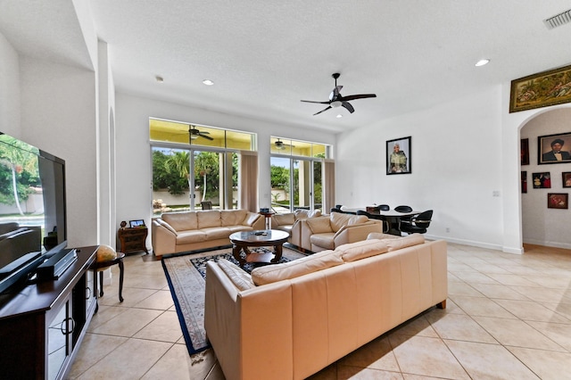 tiled living room featuring a textured ceiling and ceiling fan