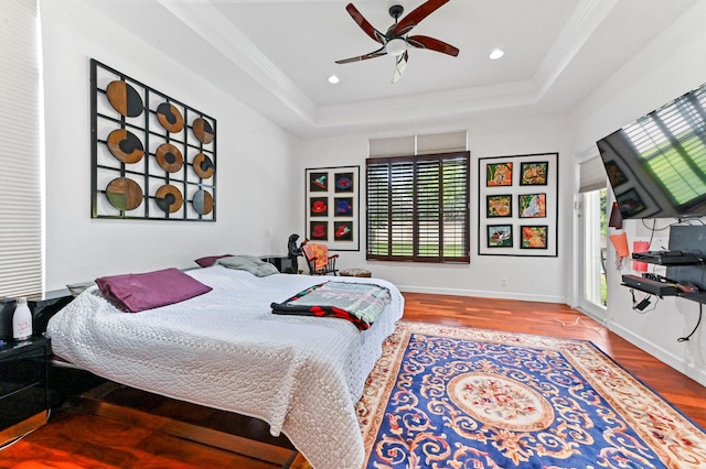 bedroom featuring crown molding, ceiling fan, a tray ceiling, and wood-type flooring