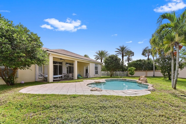 view of pool with a patio area, ceiling fan, and a lawn