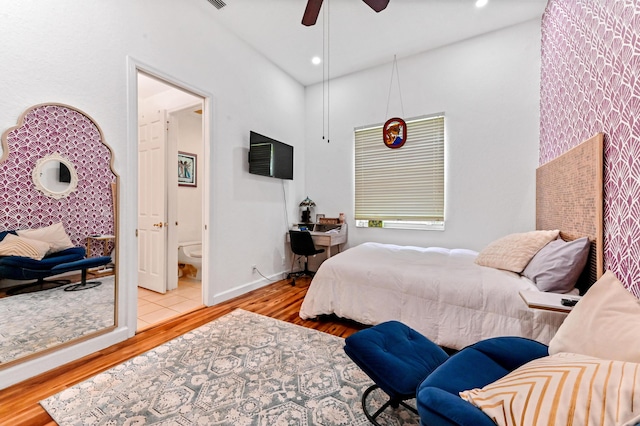 bedroom with ensuite bath, ceiling fan, and light hardwood / wood-style flooring