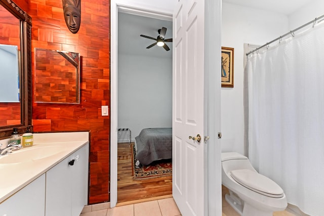 bathroom with toilet, tile patterned flooring, ceiling fan, and vanity