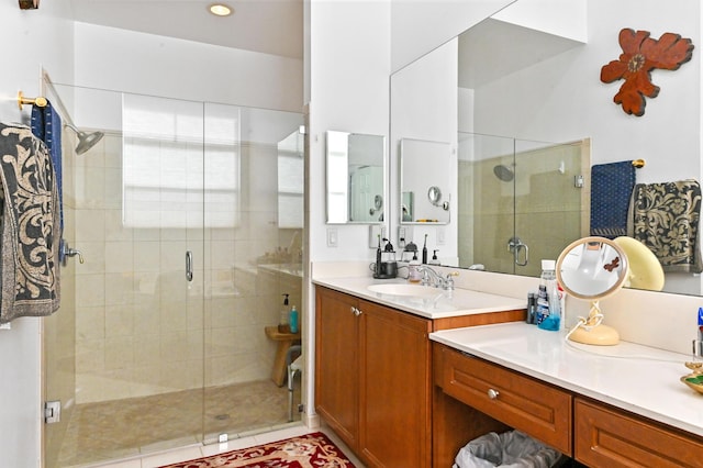 bathroom featuring tile patterned flooring, a shower with shower door, and vanity