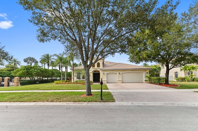 mediterranean / spanish-style home with a front yard and a garage