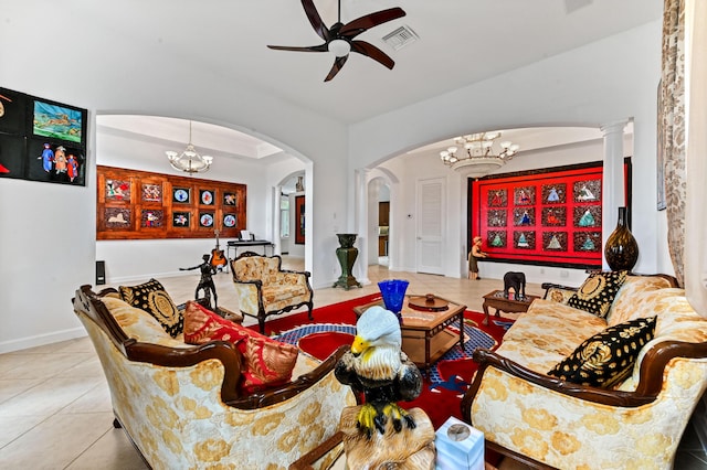 living room featuring ceiling fan with notable chandelier, decorative columns, and light tile patterned floors