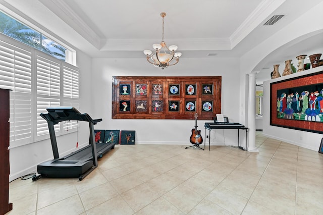 workout room featuring decorative columns, a tray ceiling, crown molding, and a chandelier