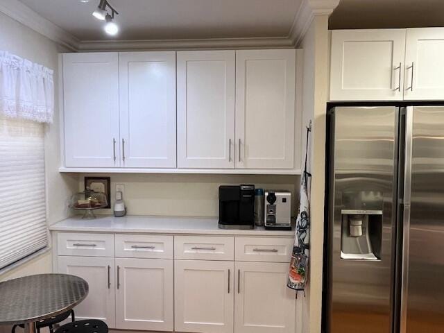 kitchen featuring crown molding, white cabinetry, and stainless steel refrigerator with ice dispenser