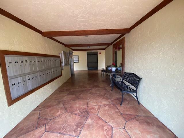 hall with a textured ceiling, beam ceiling, and a mail area