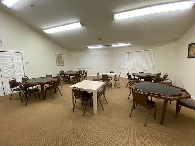 carpeted dining room with vaulted ceiling