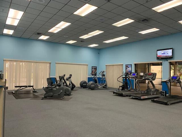 workout area with carpet flooring, a towering ceiling, and a paneled ceiling