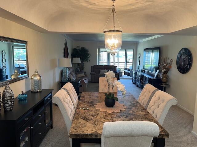 dining room with brick ceiling, carpet, vaulted ceiling, and an inviting chandelier