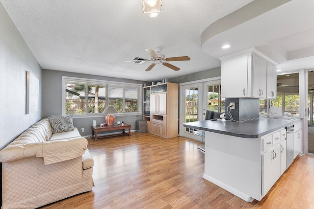 kitchen with ceiling fan, white cabinetry, light hardwood / wood-style floors, and french doors