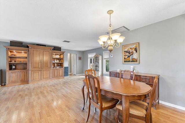 dining space featuring light hardwood / wood-style flooring and a chandelier