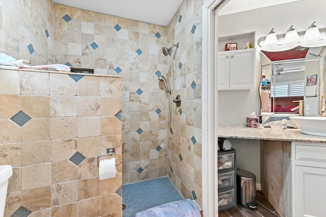 bathroom featuring a tile shower and vanity