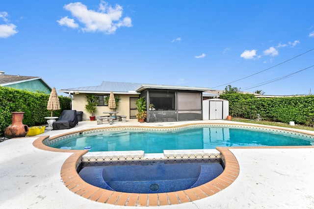 view of pool featuring a patio area, a sunroom, and a storage shed