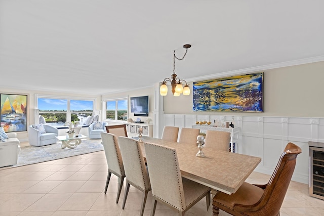 dining area featuring light tile patterned flooring, crown molding, and a chandelier