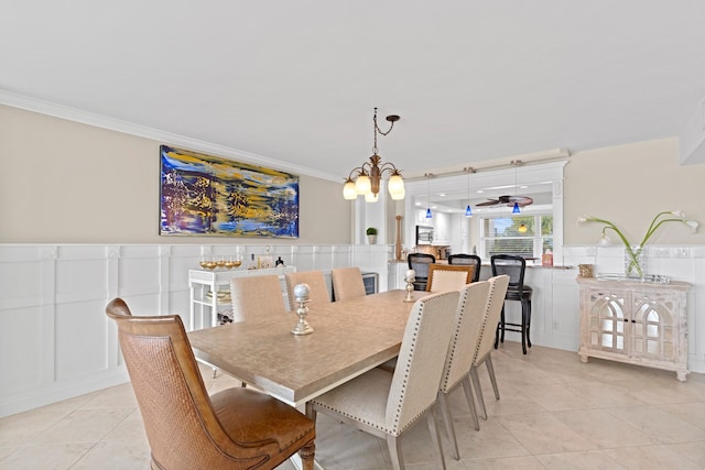 tiled dining area featuring ceiling fan with notable chandelier and crown molding