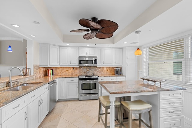 kitchen featuring stainless steel appliances, sink, kitchen peninsula, a breakfast bar area, and pendant lighting