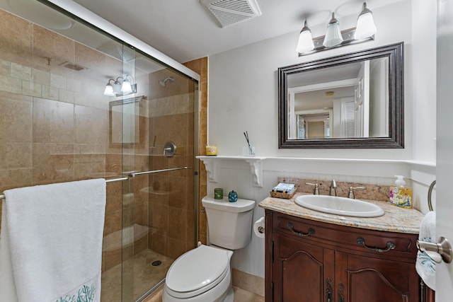 bathroom featuring toilet, walk in shower, and vanity