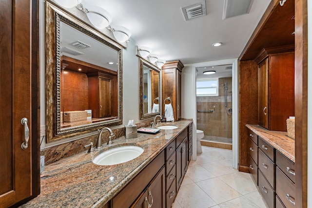 bathroom featuring vanity, tile patterned flooring, a shower with shower door, and toilet