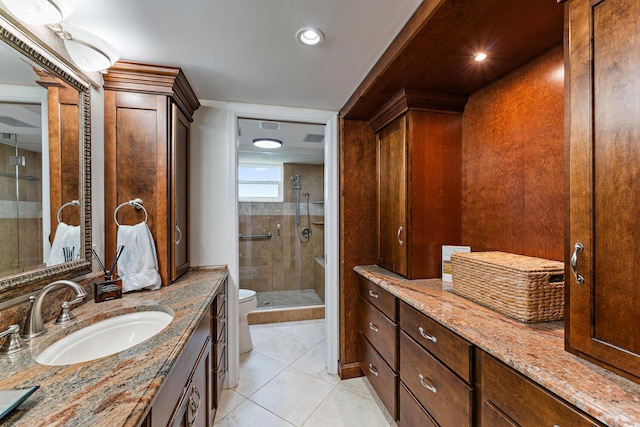 bathroom with toilet, tile patterned floors, a shower with shower door, and vanity