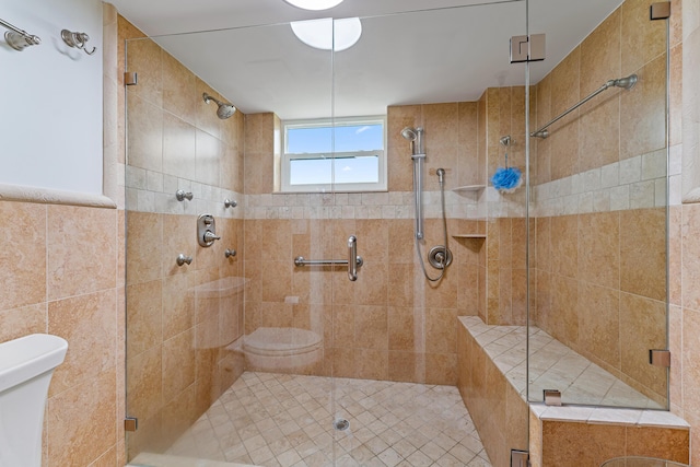 bathroom with a shower with door and toilet