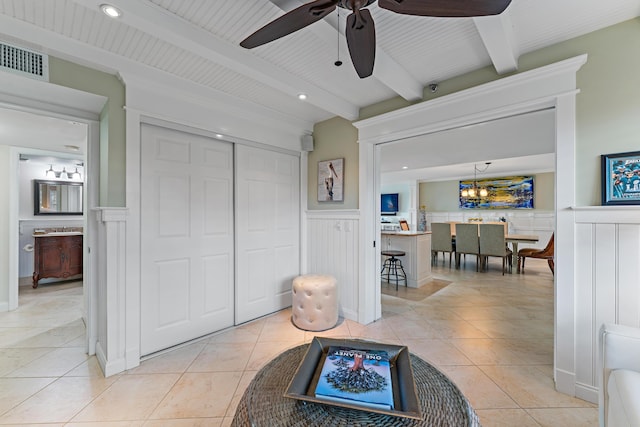 interior space featuring beam ceiling and ceiling fan with notable chandelier