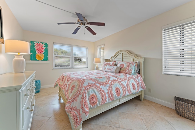 bedroom with ceiling fan, light tile patterned floors, and multiple windows