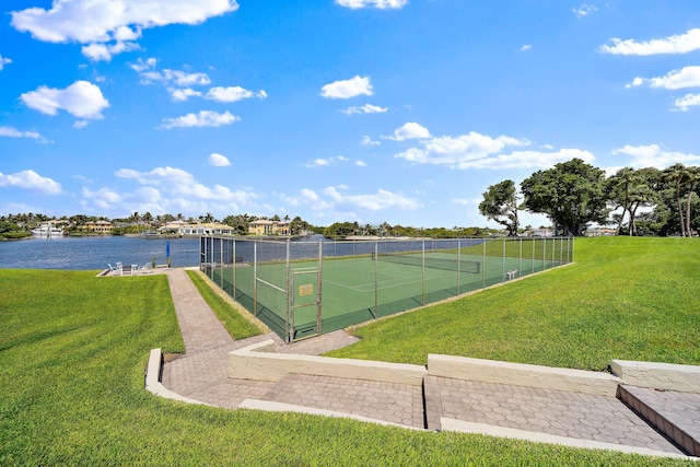 view of sport court featuring a yard and a water view