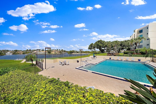 view of swimming pool with a patio and a water view