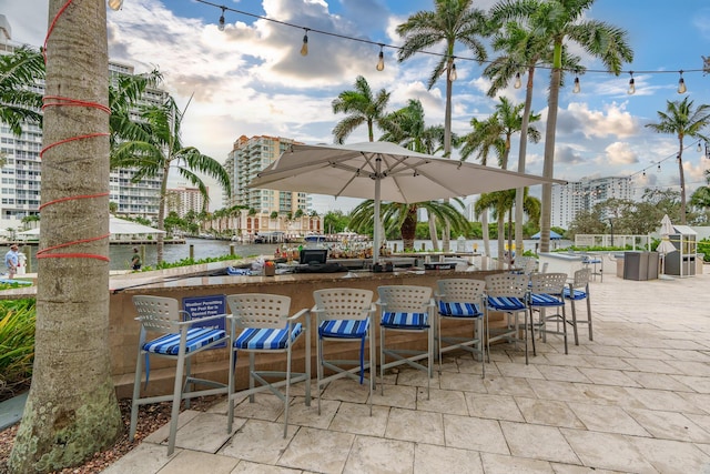 view of patio / terrace featuring a water view and a bar