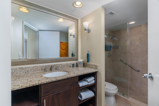 bathroom featuring a shower with door, vanity, and toilet