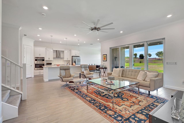 living room with ceiling fan, ornamental molding, and light hardwood / wood-style floors