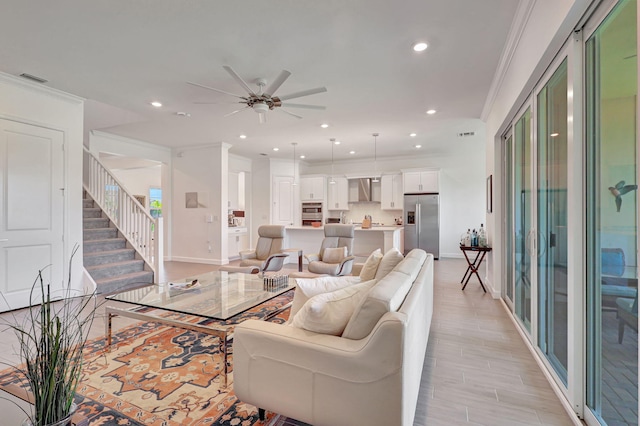 living room with ceiling fan and ornamental molding