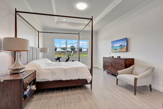 bedroom with ornamental molding and a raised ceiling