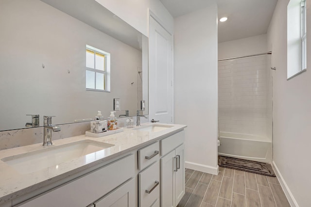 bathroom with tiled shower / bath combo and vanity