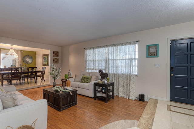 living room with light wood-type flooring and a textured ceiling