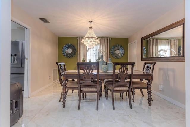 dining room featuring a textured ceiling and an inviting chandelier