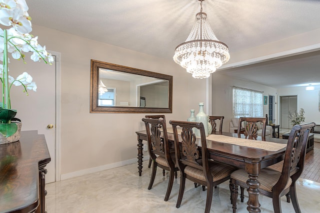 dining space featuring a chandelier and a textured ceiling