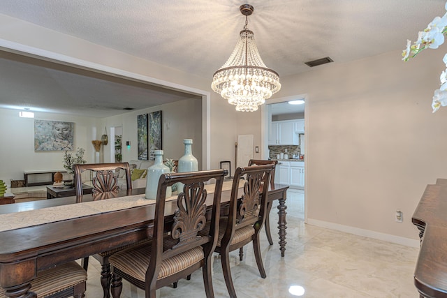 dining area featuring a textured ceiling and an inviting chandelier