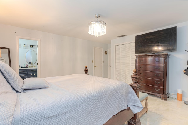 bedroom featuring ensuite bath and an inviting chandelier