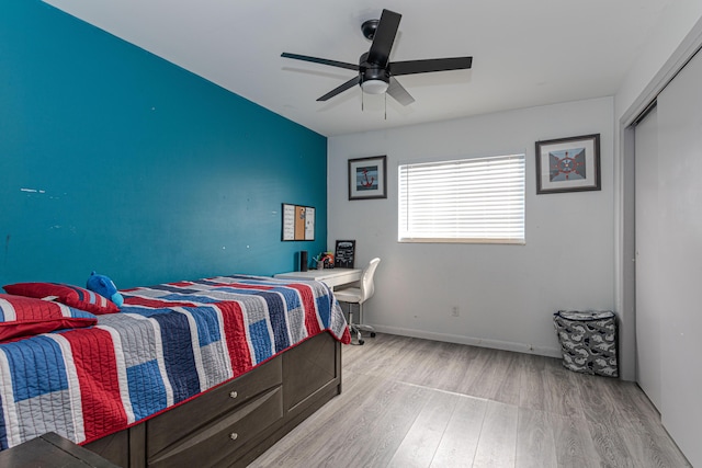 bedroom with ceiling fan, a closet, and light hardwood / wood-style floors