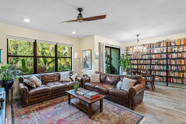 living room with a textured ceiling, light hardwood / wood-style flooring, and a wealth of natural light