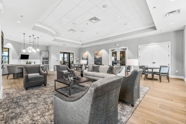 living room featuring french doors and a tray ceiling